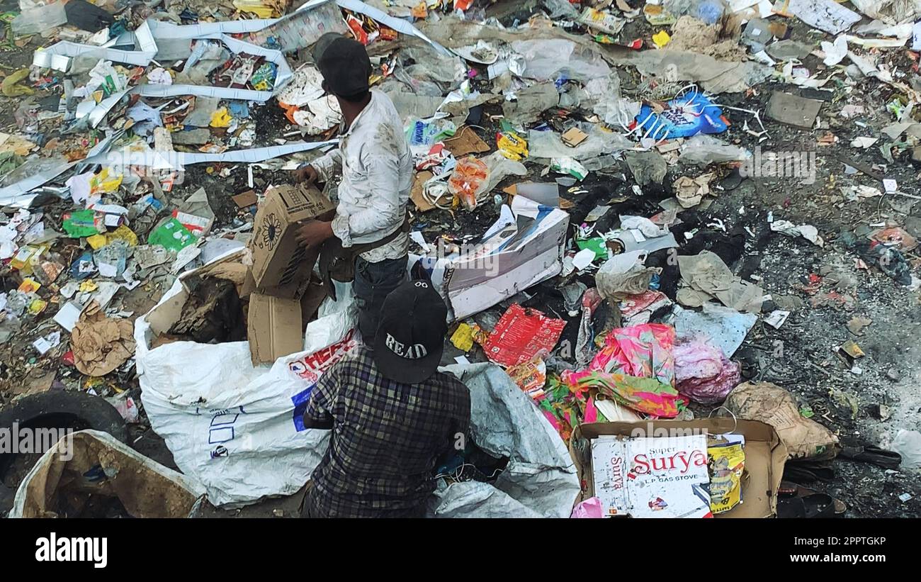 Fumo tossico nelle discariche: Lavoratori sanitari che smistano i rifiuti in mezzo a pericoli ambientali Foto Stock