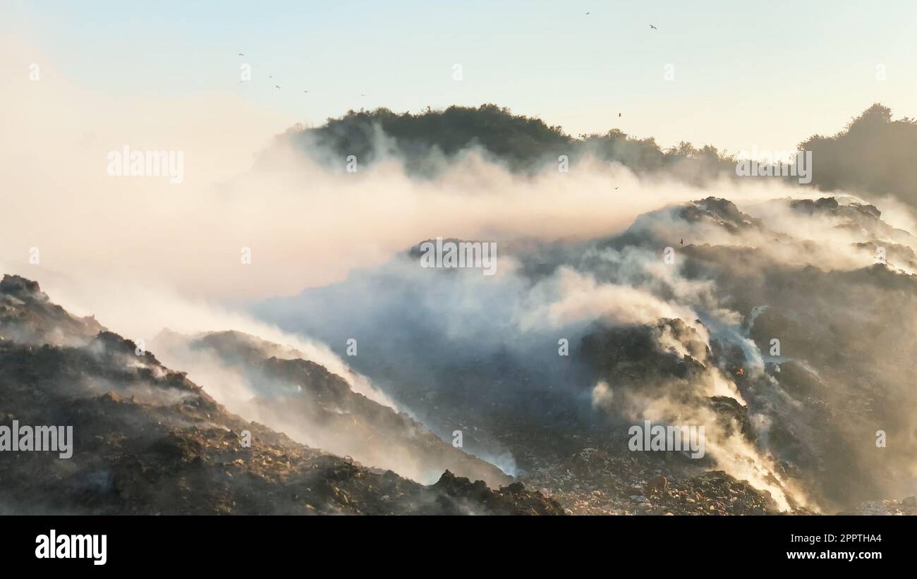 Cumulo di rifiuti in discarica o in discarica che rilascia fumo tossico nell'ambiente e nell'aria inquinante Foto Stock