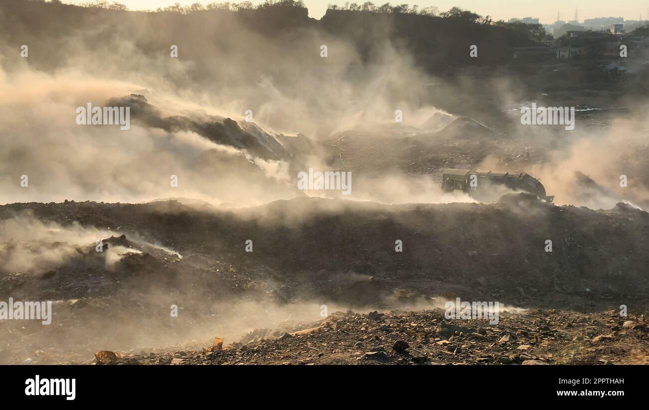 Cumulo di rifiuti in discarica o in discarica che rilascia fumo tossico nell'ambiente e nell'aria inquinante Foto Stock