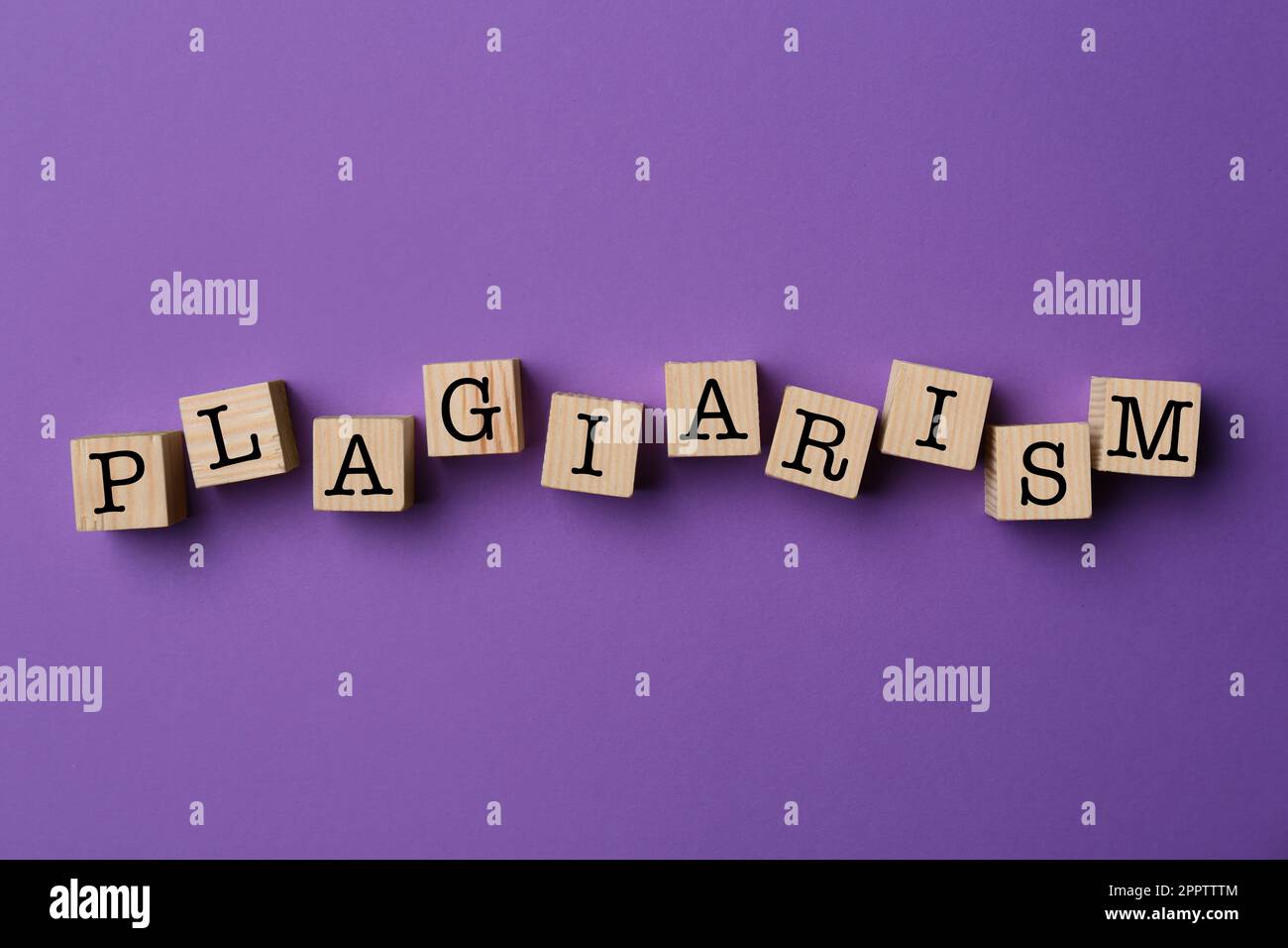 Plagio di parole fatto di cubi di legno su sfondo viola, vista dall'alto Foto Stock