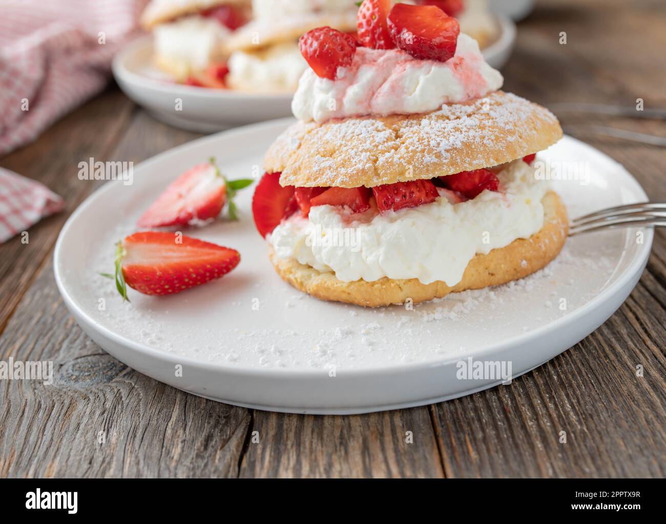Pasta di fragole con panna montata e ripieno di fragole marinate. Dolci tipici britannici cotti al forno con crosta corta Foto Stock