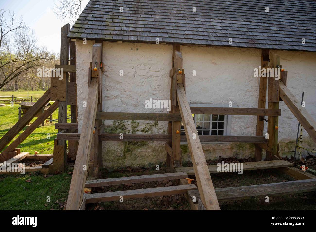 Sostegno in legno ponteggi rinforzi danneggiati cottage coloniale Foto Stock