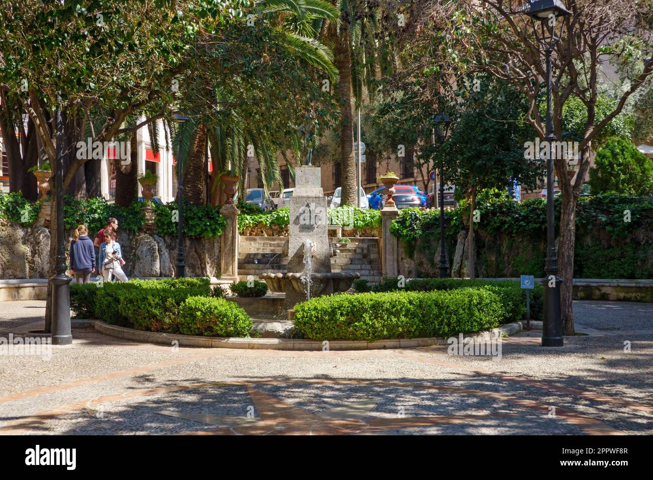 Palma, Spagna - 30 marzo, 2023, il piccolo giardino di Placa Reina si concentra intorno a un monumento e una piccola fontana in onore di Joan Alcover, un poeta di Palma Foto Stock