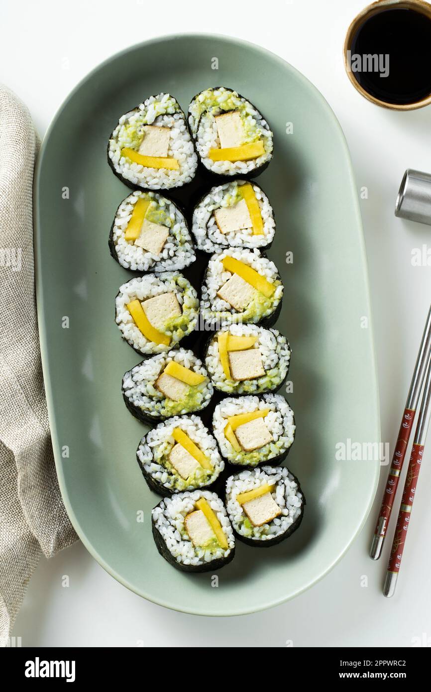 Sushi vegano con tofu, avocado e mango. Cibo sano Foto Stock