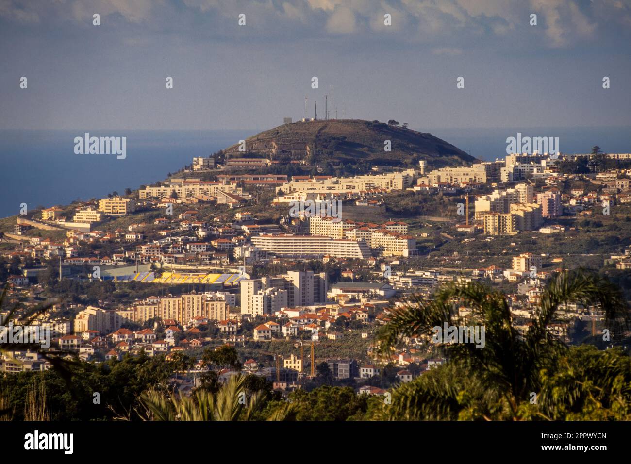 Vista rialzata di Funchal con i suoi appartamenti in bianco e l'oceano Atlantico in lontananza. Maderia. Foto Stock
