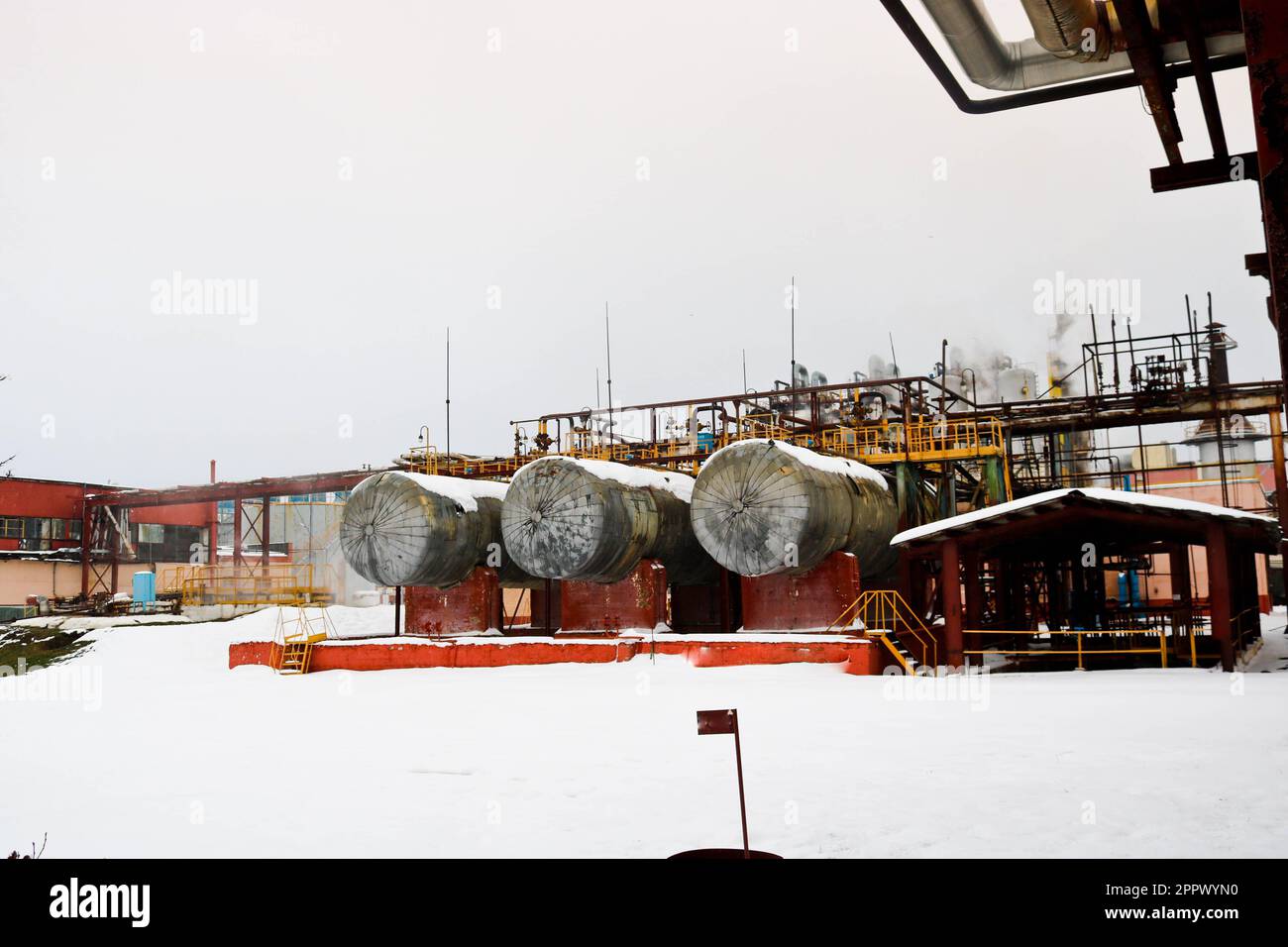 Grandi serbatoi di ferro, scale e tubi di protezione recinzione attrezzature e macchine utensili valvole scambiatori di calore presso una chimica petrolchimica di raffinazione del petrolio Foto Stock