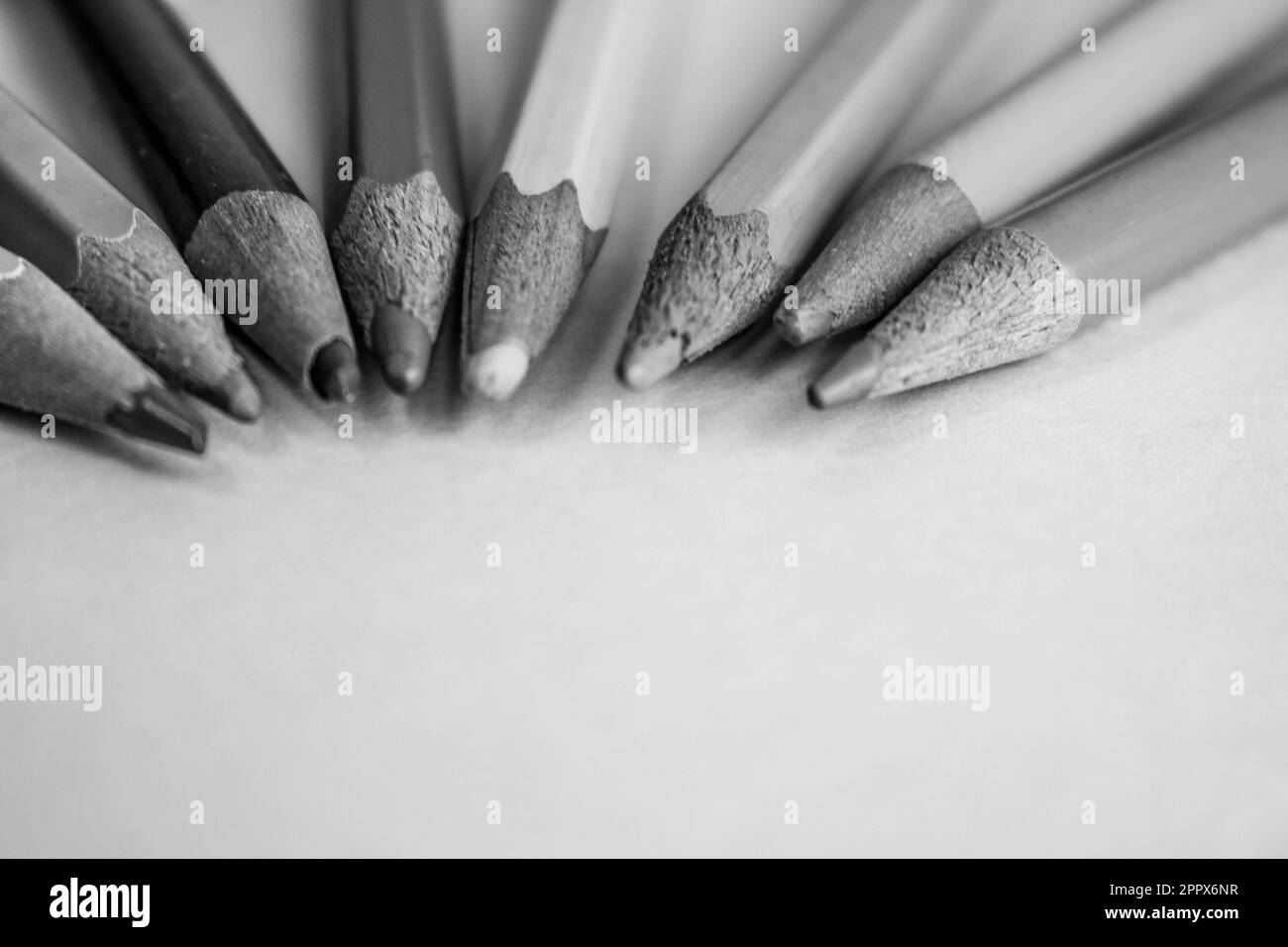 Belle matite affilanti colorate in legno di colore brillante per il disegno. Disposizione piatta e spazio di copia su uno sfondo bianco e nero. Foto Stock