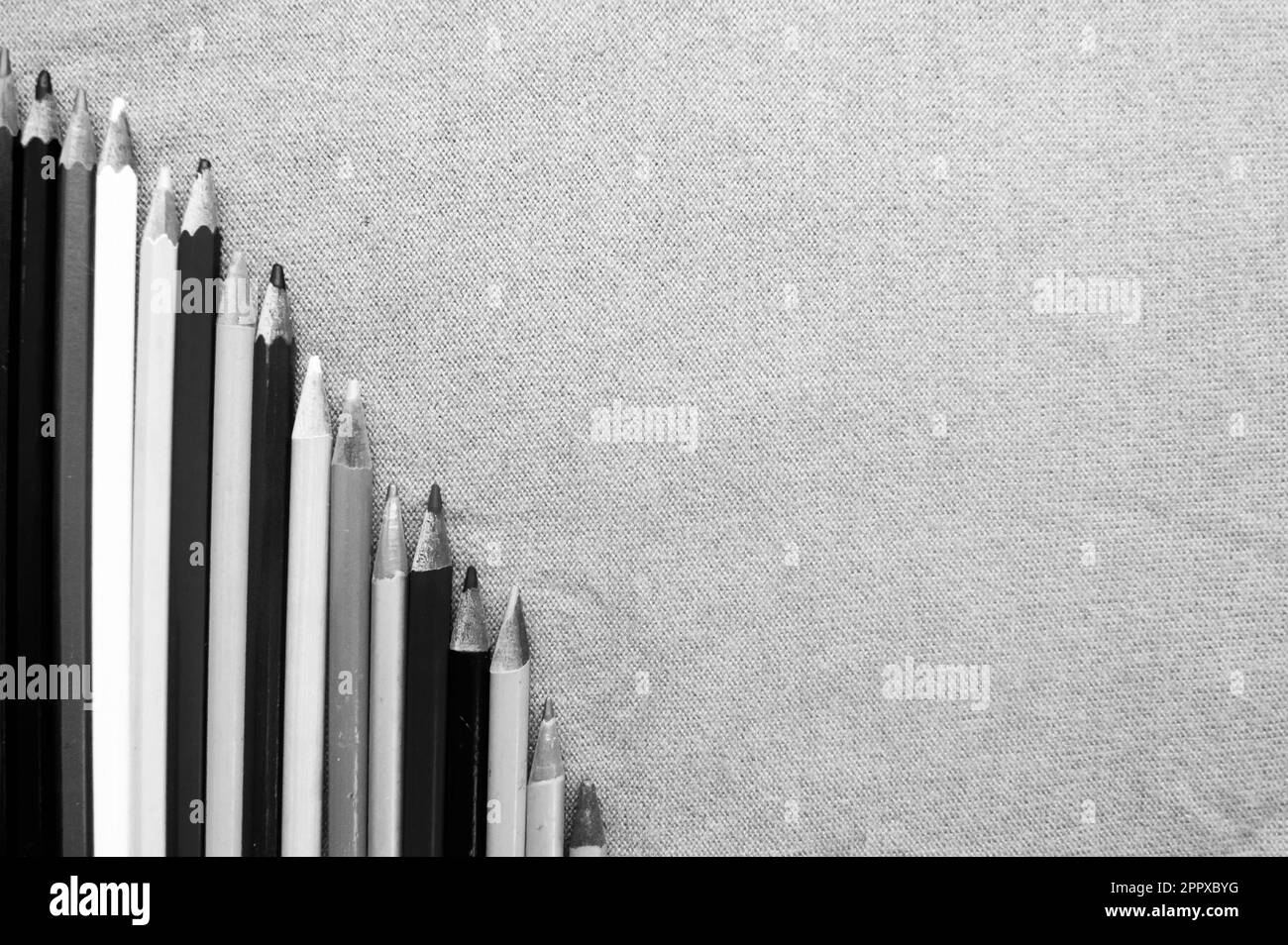 Un grafico discendente di matite da disegno colorate, luminose e variegate e spazio per il testo su uno sfondo viola. Foto Stock
