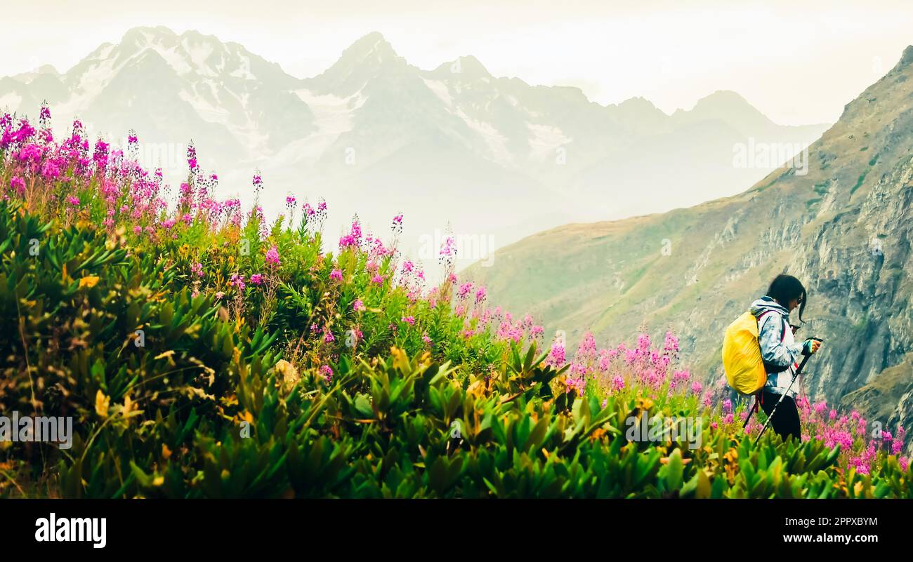 Escursionista femminile con nordic Walk pols escursione in discesa nel verde caucasica montagne sentiero escursionistico in primavera natura piovoso day.Recreational attività e healt Foto Stock