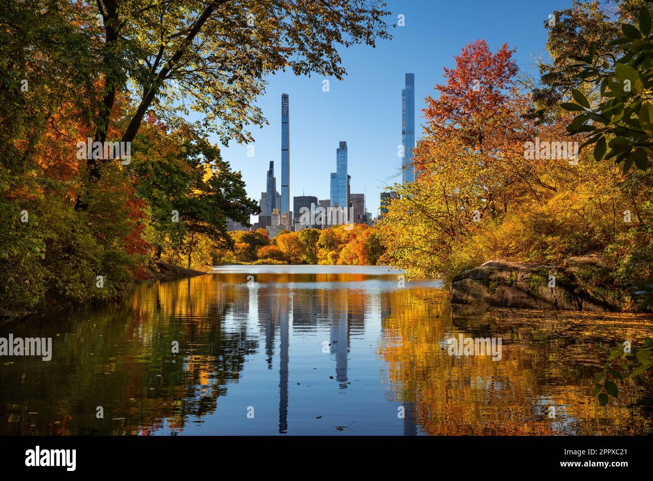 Central Park in autunno con vista dei grattacieli della fila dei miliardari dal lago. Manhattan, New York City Foto Stock