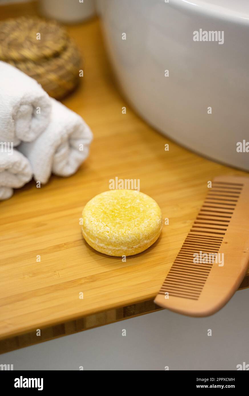 Shampoo bar solido sostenibile e accessori per il bagno sdraiati su un tavolo di bambù. Senza plastica, senza sprechi, ingredienti a basso contenuto d'acqua. Capelli eco-compatibili Foto Stock