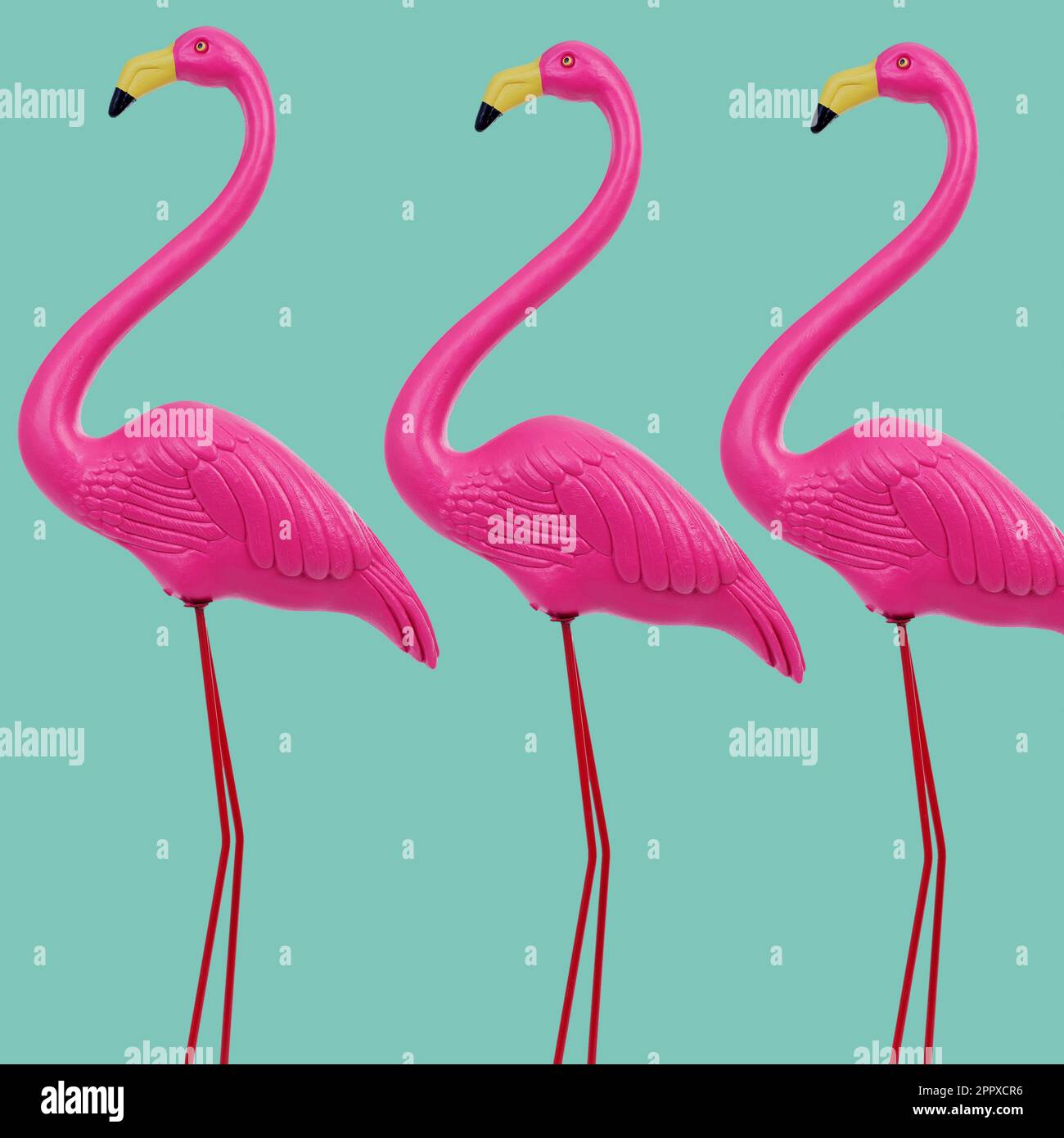 tre finti fenicotteri rosa su sfondo verdastro Foto Stock