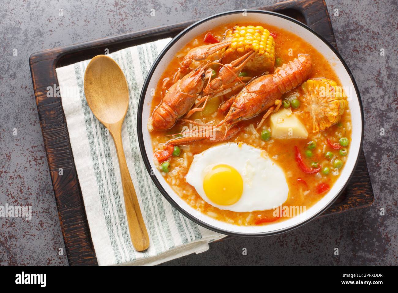 Zuppa di gamberi con pomodori, mais, pepe, patate e uova in un recipiente sul tavolo. Vista orizzontale dall'alto Foto Stock