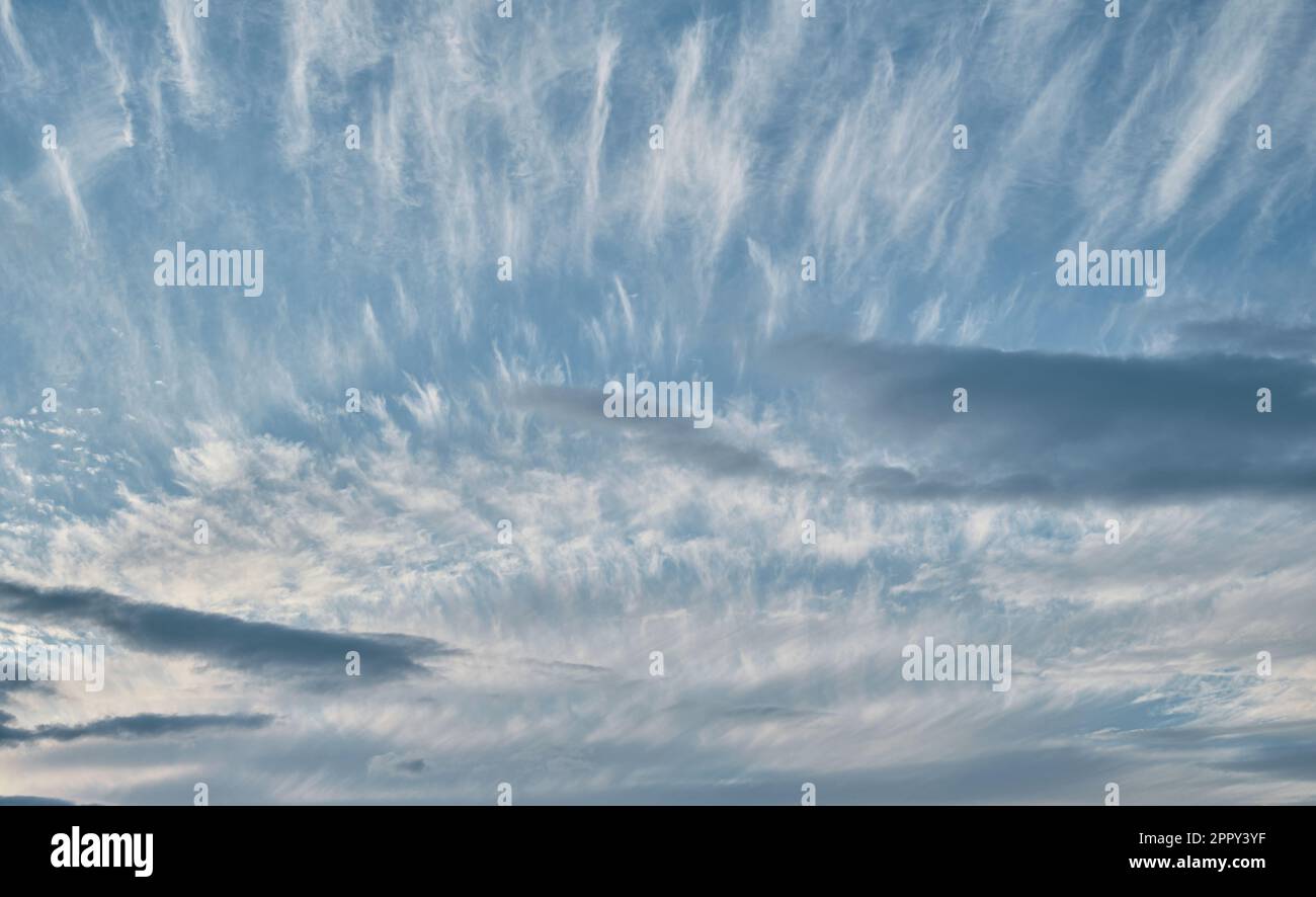 Cielo con le nuvole di cirrus e di stratus, sfondo diurno contrastante della natura, cambiamenti climatici, tramonto Foto Stock