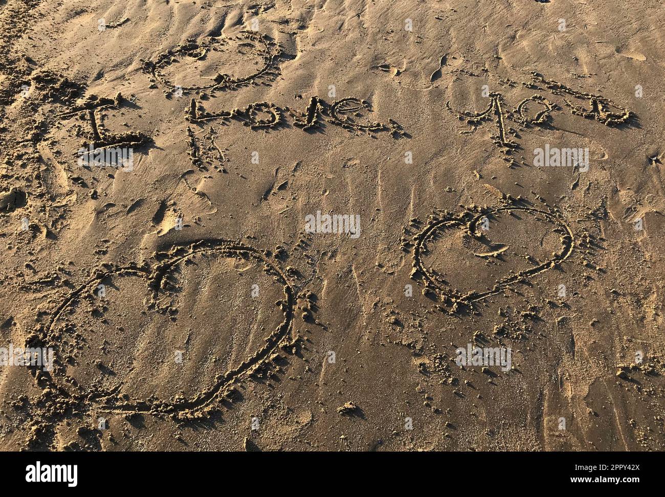 Incantevole spiaggia scena: Vi amo con tre cuori scritti disegnati nella sabbia, vacanza romantica, San Valentino, matrimonio, relazioni, amanti famiglia Foto Stock