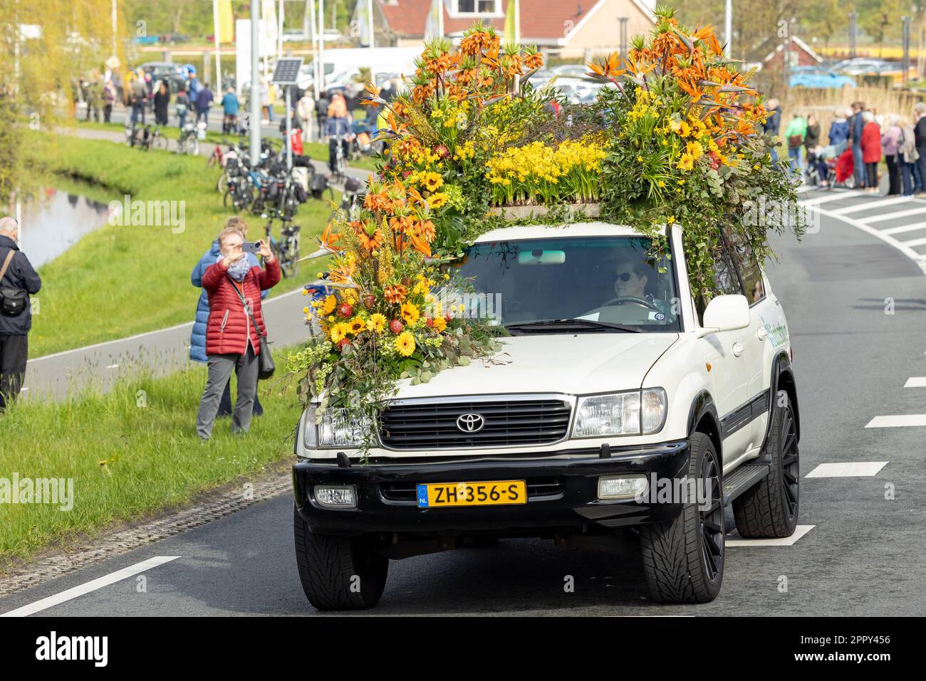 Noordwijk, PAESI BASSI - 22 aprile 2023: Auto di lusso colorata con fiori gialli e arancioni durante la tradizionale sfilata di fiori Bollenstreek Bl Foto Stock