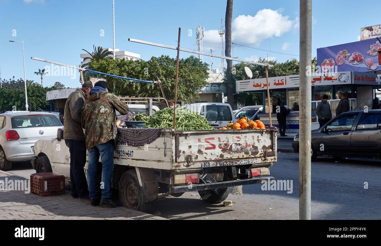 Sousse, Tunisia, 31 gennaio 2023: Venditori di strada di verdure, fagioli, frutta e arance da un vecchio camion giapponese martellato pick-up sul lato del Foto Stock