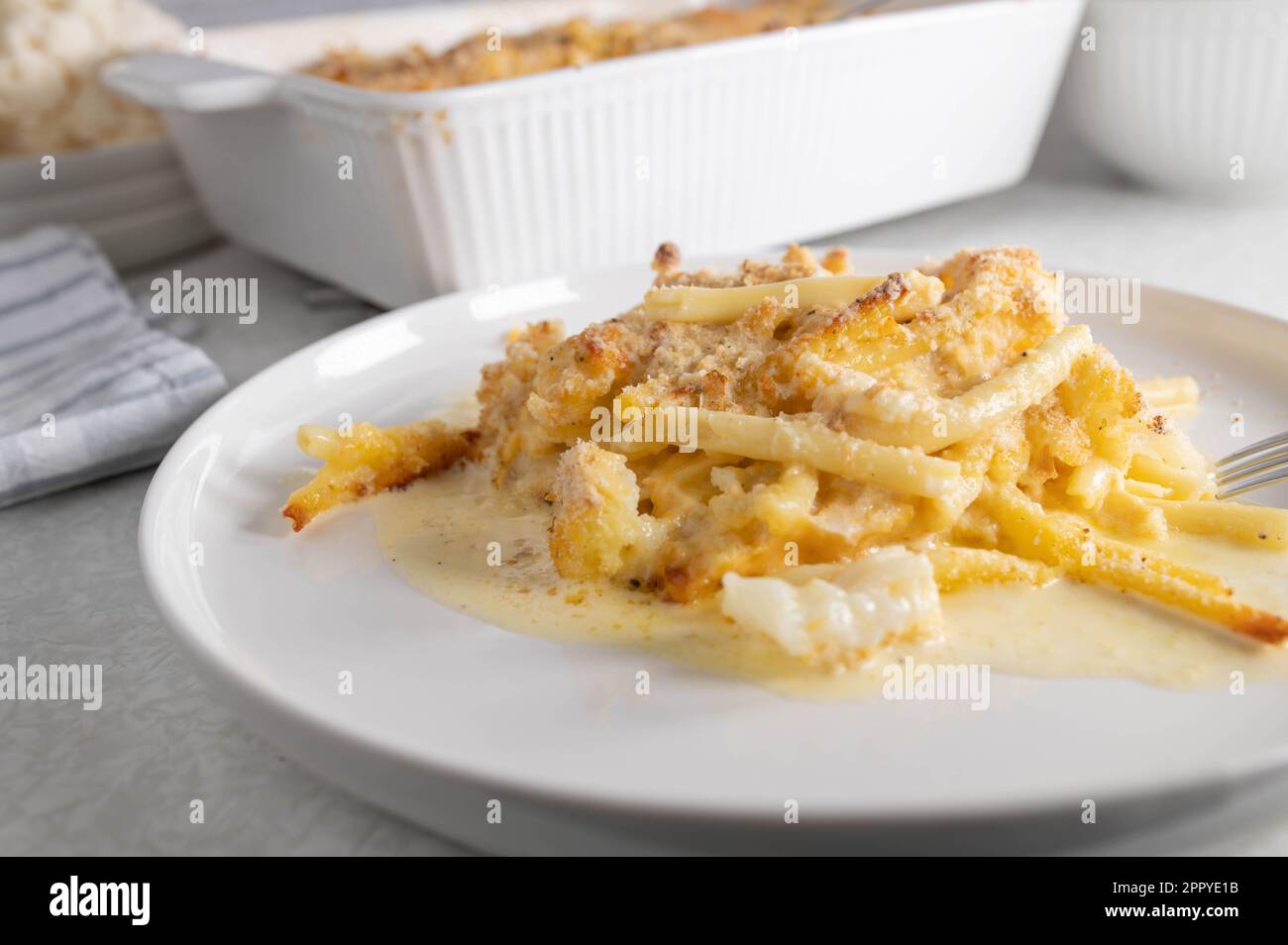 Casseruola di spaghetti con maccheroni e salsa al formaggio. Al forno con cavolfiore e condito con pangrattato e parmigiano. Foto Stock