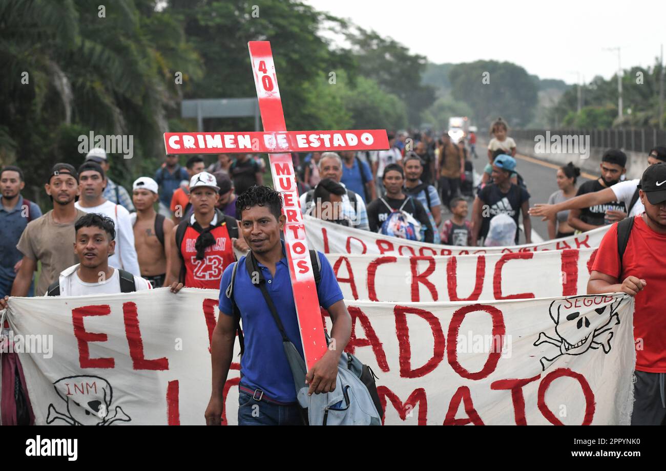 Huehuetan, Messico. 25th Apr, 2023. '40 morti - crimine di stato,' è scritto sulla croce portata da un migrante come egli cammina attraverso il Messico. Le circa 3.000 persone, soprattutto dell'America centrale, che si sono insediate a nord domenica, vogliono richiamare l'attenzione sulla loro situazione e chiedere giustizia dopo la morte di 40 migranti in una struttura per l'immigrazione. Credit: Isaac Guzman/dpa/Alamy Live News Foto Stock