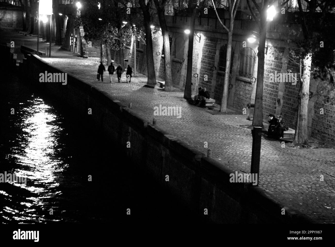 Persone di notte sulla riva del fiume Senna, Parigi Foto Stock