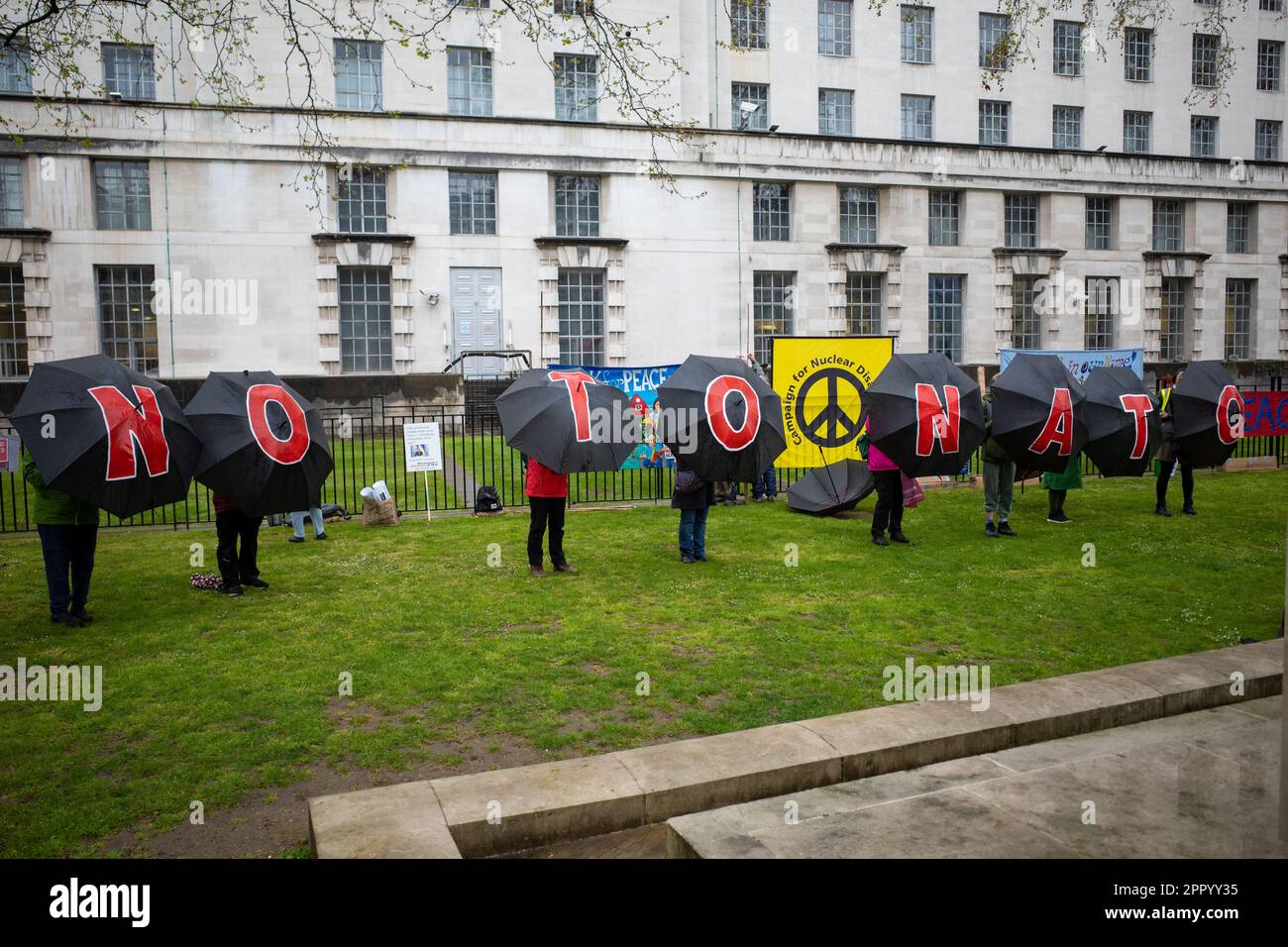 Gli ombrelli spiegano 'No alla NATO' al di fuori del Ministero della Difesa, durante il fine settimana di proteste della ribellione di estinzione 'The Big One' a Londra, 2023 aprile. Foto Stock