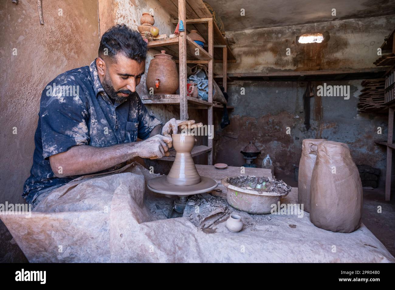 Artigiano che produce un recipiente in ceramica su un banco con una ruota di vasaio. Foto Stock