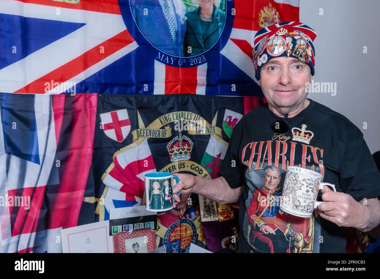 Londra, Regno Unito. 25th aprile 2023. John Loughrey, super fan reale, posa con alcuni dei suoi cimeli di re Carlo III prima dell'incoronazione di sua Maestà il 6th maggio. Ispirato da sua madre, John è stato un sostenitore reale fin dall'infanzia e ha raccolto una grande collezione di cimeli della famiglia reale britannica per molti decenni. Foto di Amanda Rose/Alamy Live News Foto Stock