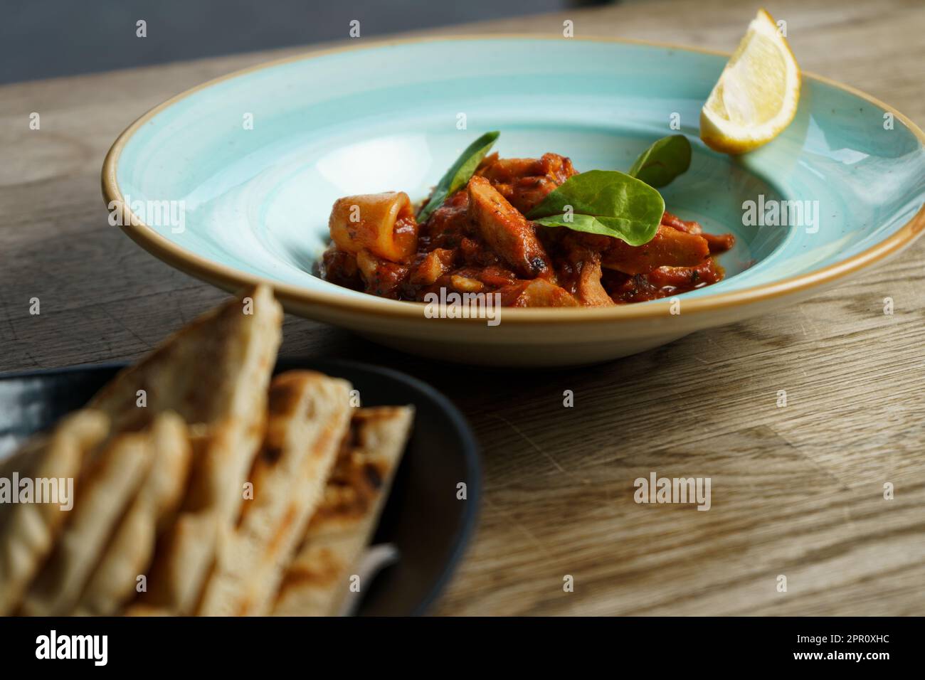 Calamari con salsa piccante di pomodoro, limone e pane greco Pita Foto Stock