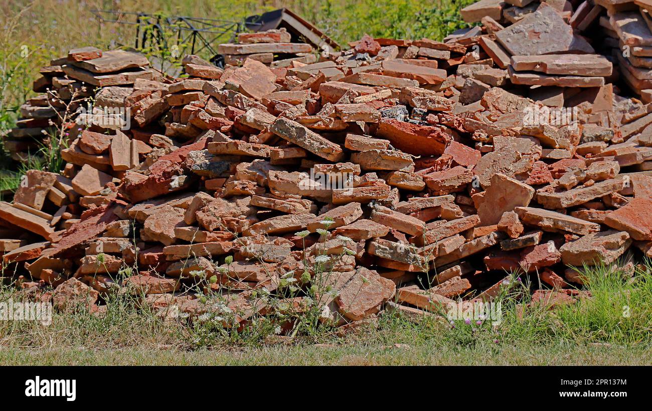 I vecchi mattoni riciclati si accumulano sui detriti del cantiere Foto Stock