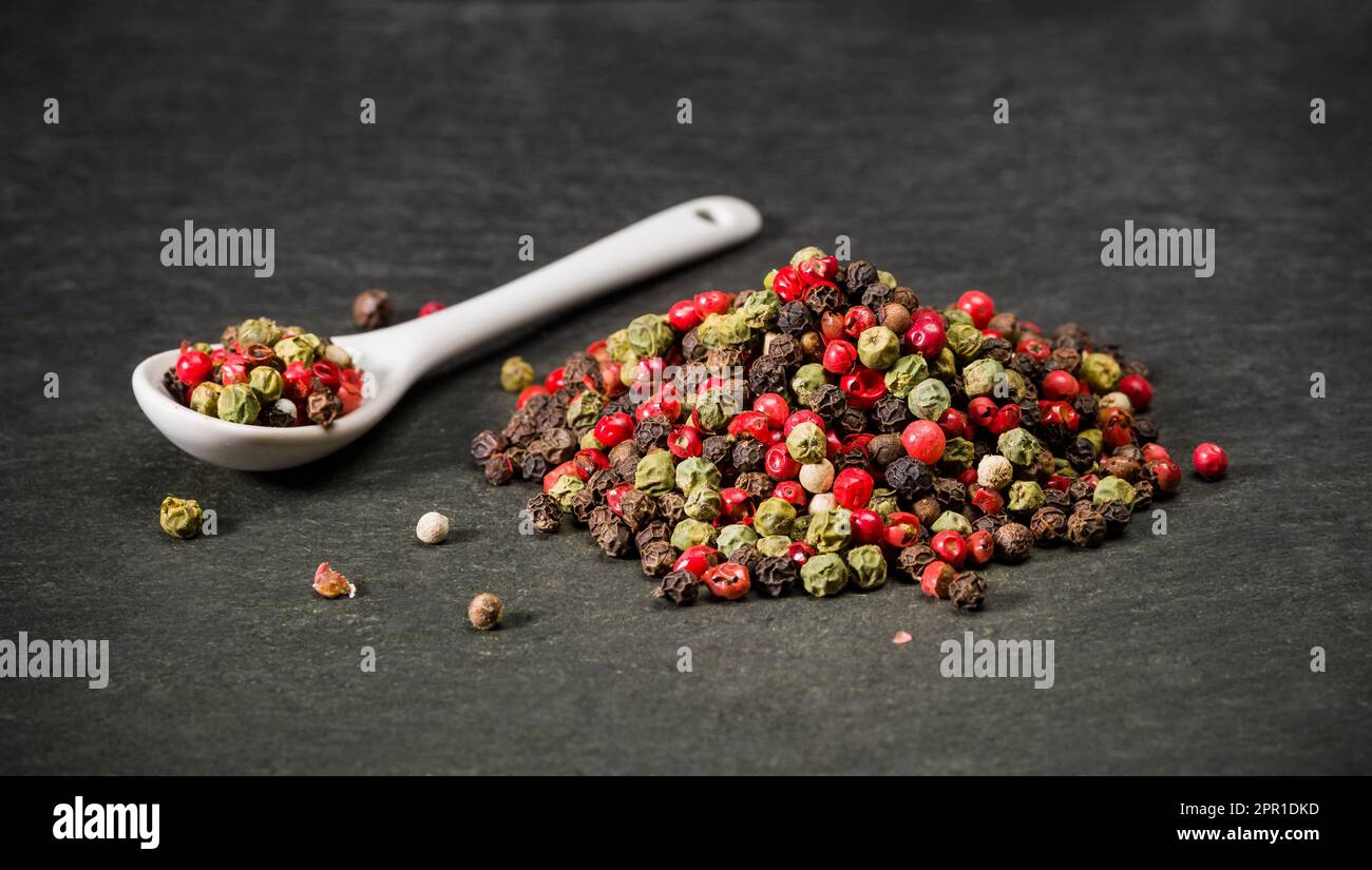 Pepe macinato secco mescolare spezie per le ricette. Un cucchiaio e un mucchio di pepe in polvere caldo. Spezie macinate. Foto Stock