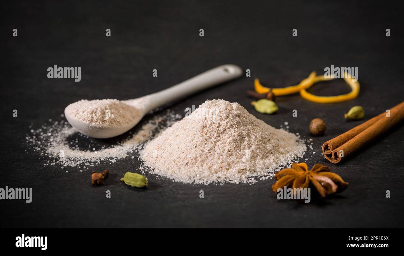 Spezie per ricette. Zucchero milanese. Cucchiaio e cumulo di zucchero, cannella, chiodo di garofano. Dolci. Spezie macinate Foto Stock