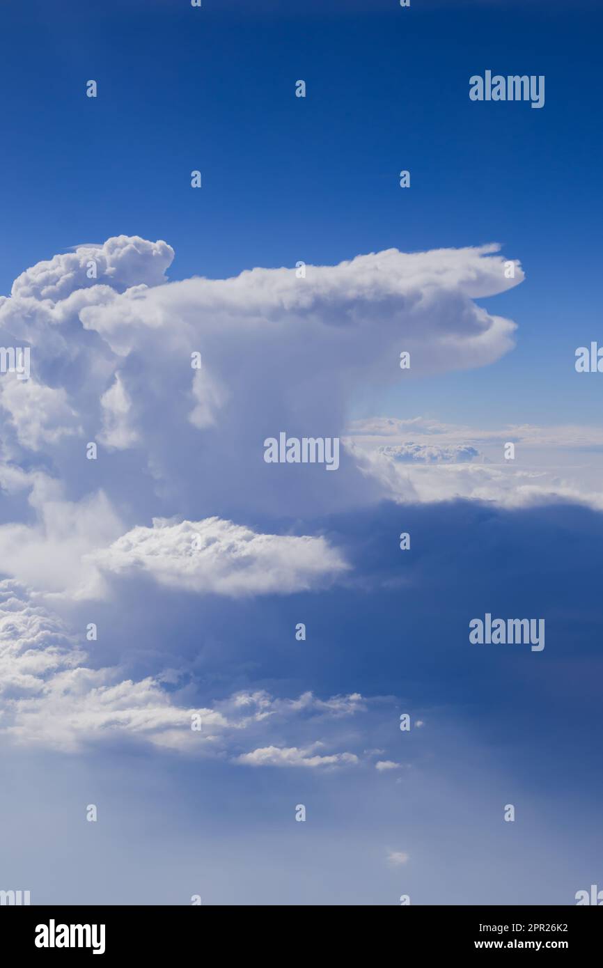 Cumulus e cumulonimbus pioggia nuvole visto da aereo. Ripresa in volo contro il cielo blu. Foto Stock