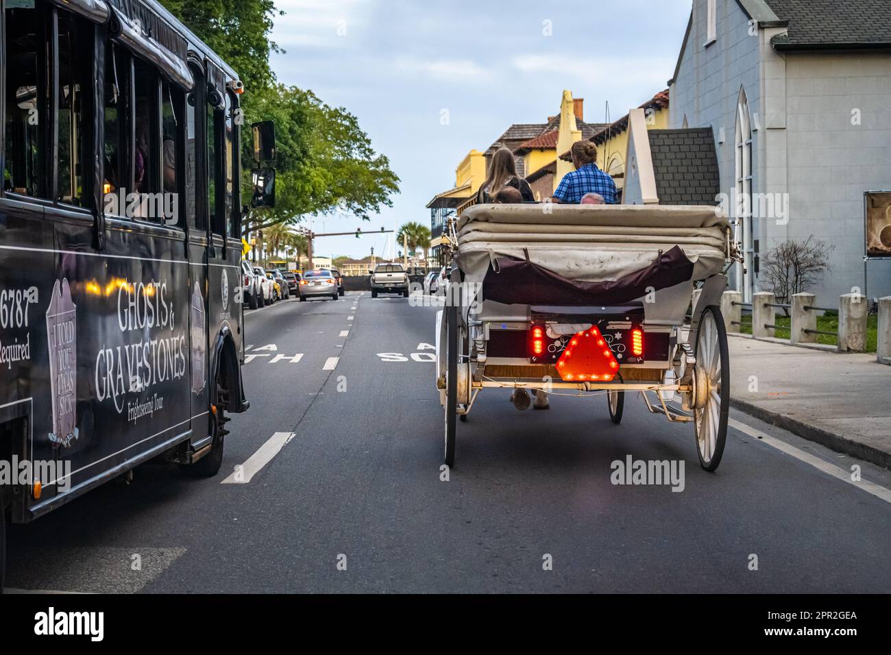 Una carrozza trainata da cavalli e un autobus turistico Ghosts & Gravestones sulla King Street che si avvicina alla Matanzas Bay nella storica Old City St Augustine, Florida. (USA) Foto Stock
