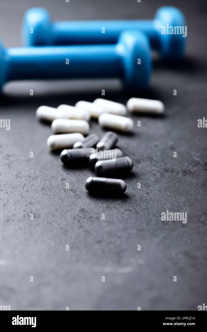Capsule di BCAA e creatie. Bodybuilding integratori alimentari su sfondo di pietra scura. Messa a fuoco morbida. Primo piano. Spazio di copia. Foto Stock