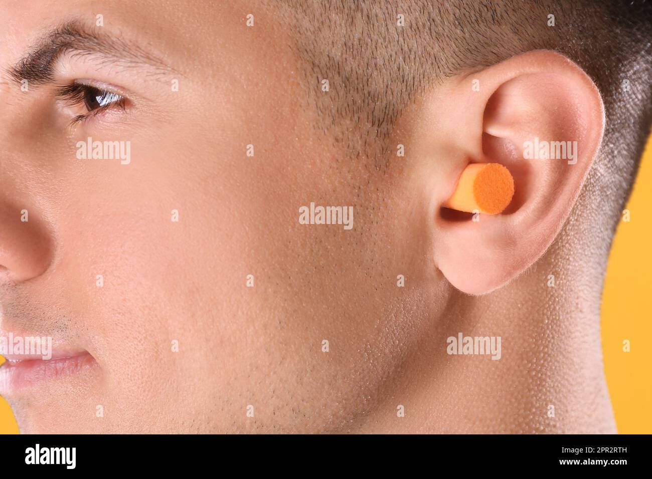 Uomo che indossa il tappo auricolare in schiuma, vista in primo piano Foto Stock