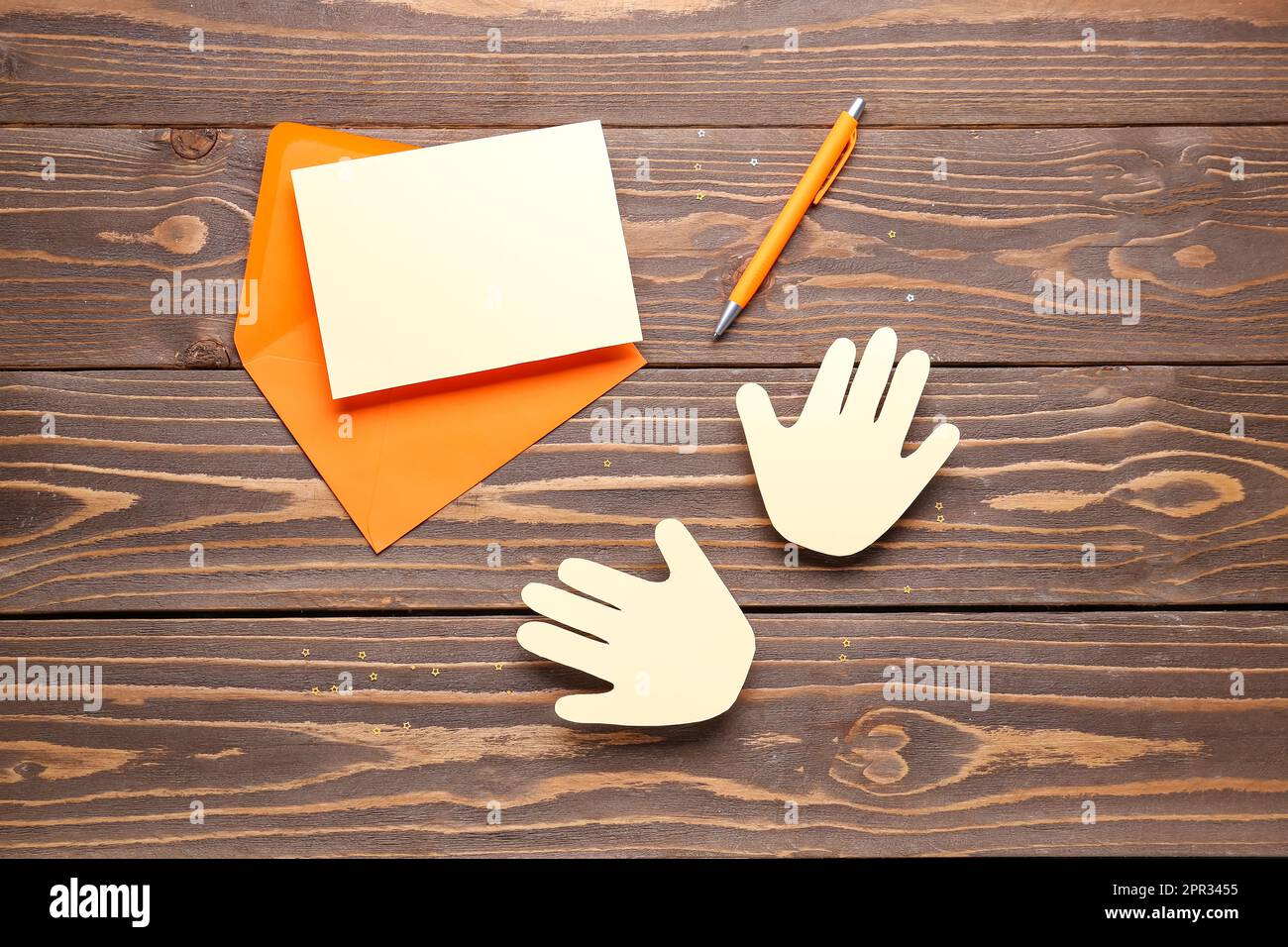 Busta con bigliettino vuoto e palme di carta su sfondo di legno. Festa dell'amicizia Foto Stock