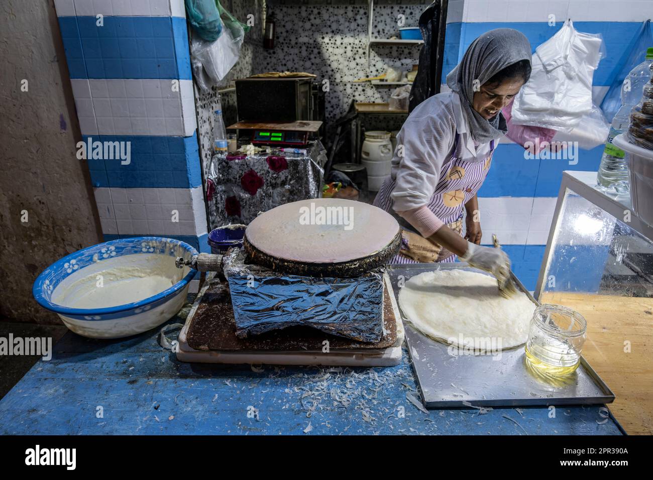 Donna che prepara i fogli di pasta per preparare dolci tipici marocchini in una bancarella di strada nella medina di Asilah. Foto Stock