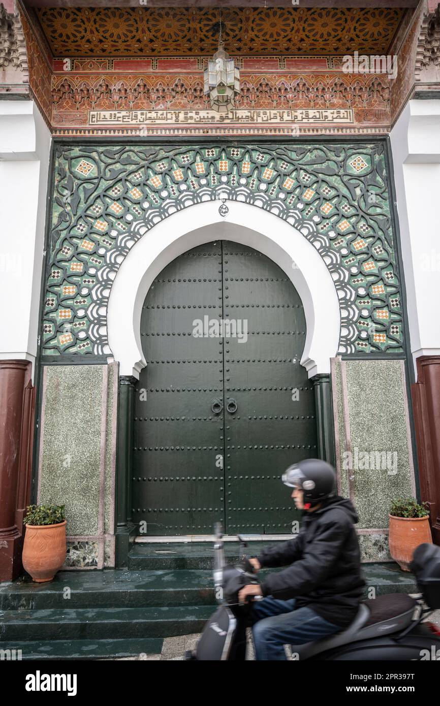 Motocicletta che passa di fronte al cancello della Grande Moschea di Tanger. Foto Stock