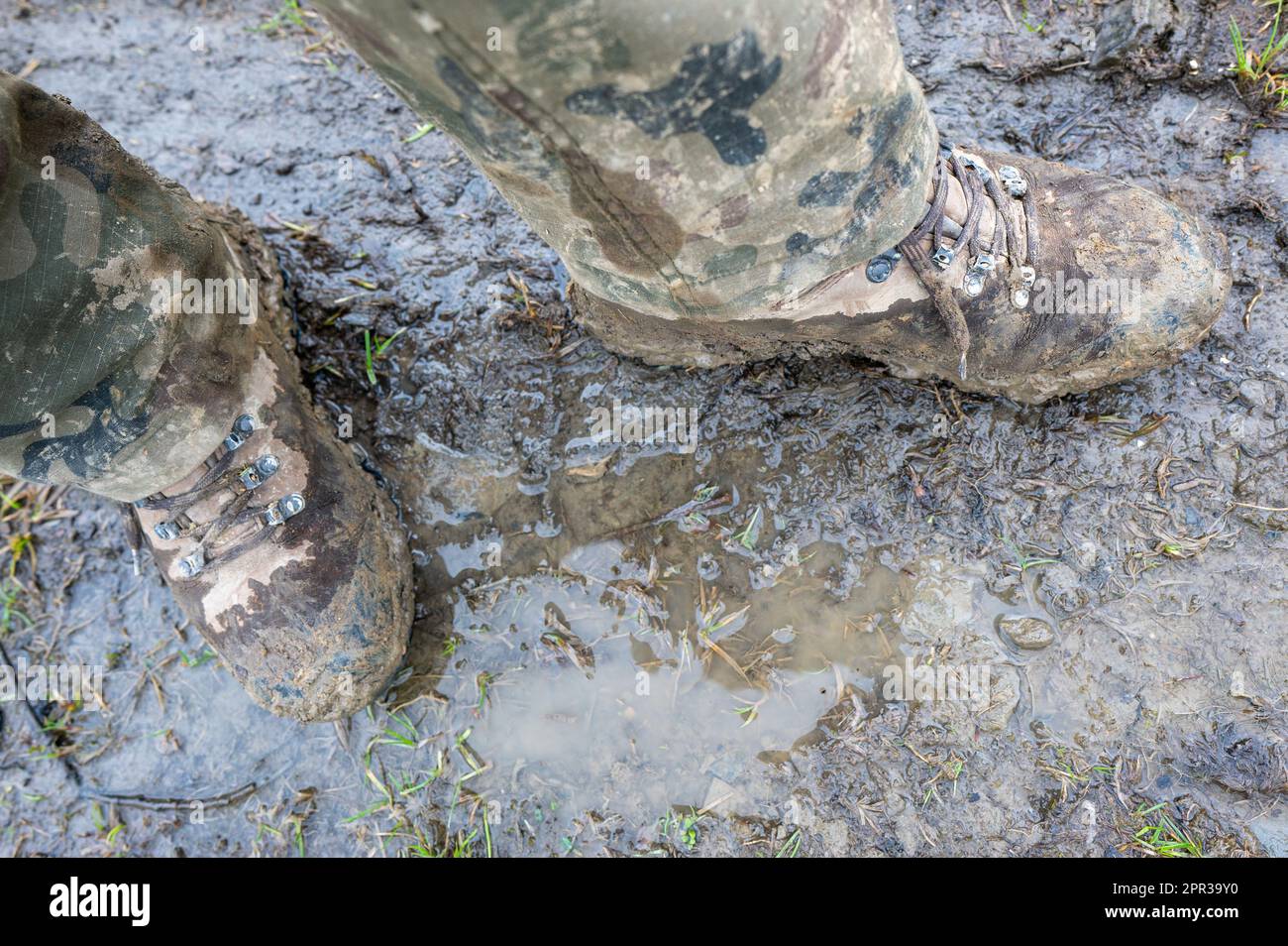 Stivali tattici sporchi del soldato dopo le esercitazioni nel fango. Foto Stock
