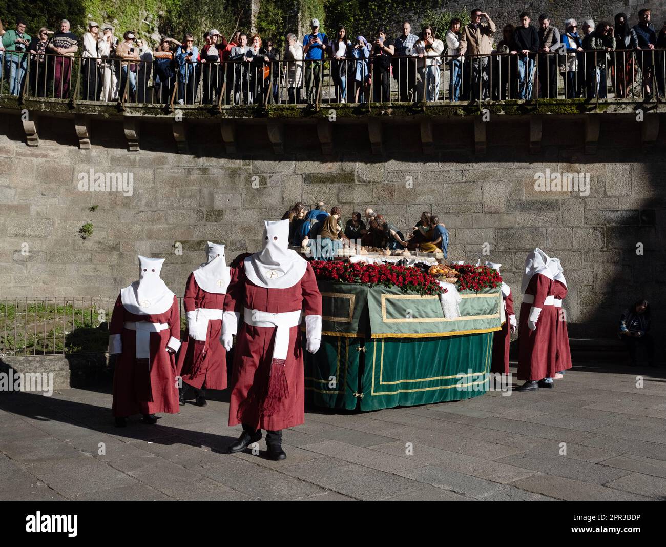 I Penitenti nascondono la loro identità con le cappe, mentre si trattano con croci, catene, o effigi, Santiago de Compostela, alla settimana di Pasqua nel nord-ovest della Spagna Foto Stock