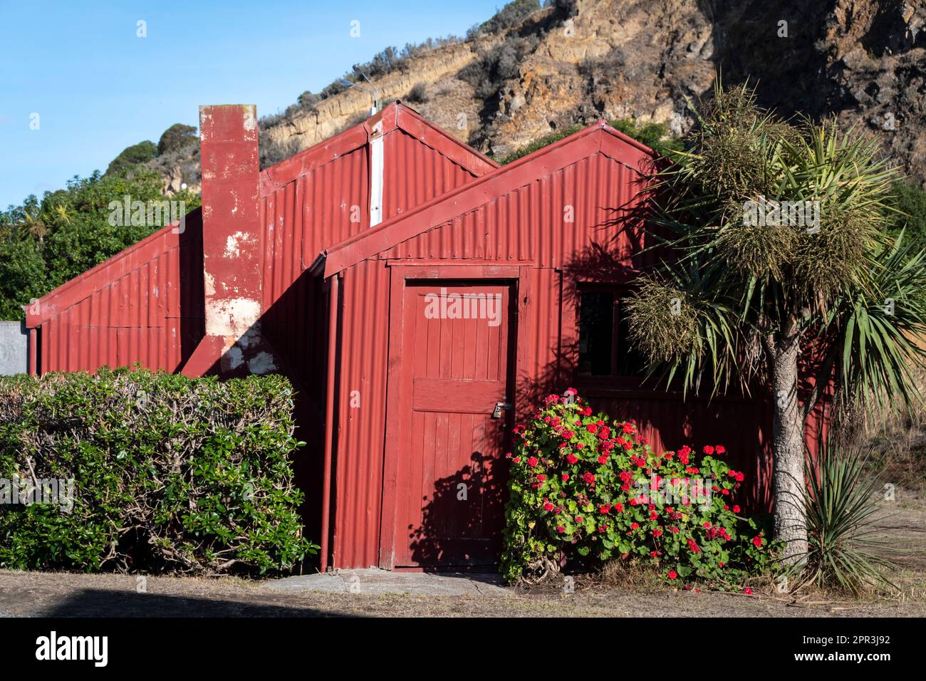 Casa di ferro corrugato rosso a Carry Siding, Oamaru, Nord Otago, Isola del Sud, Nuova Zelanda Foto Stock