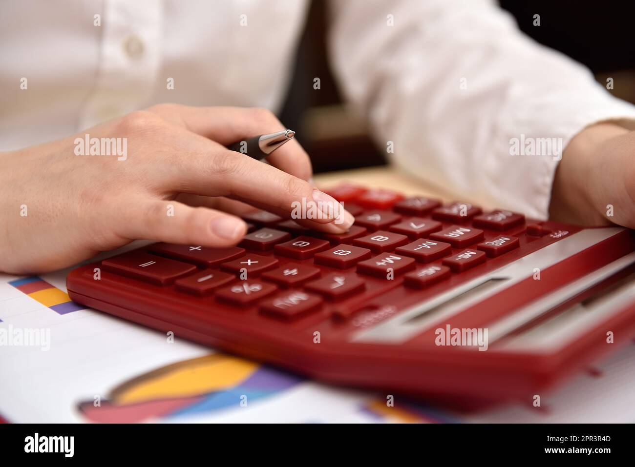 Donna d'affari che utilizza una calcolatrice e si aspetta il budget aziendale Foto Stock