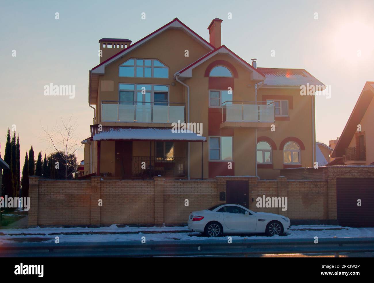 Russia, Sochi, villaggio olimpico - 31 gennaio 2017: Villa di campagna (dacha in stile legno, architettura di campagna) e auto sportiva all'ingresso, vigilia d'inverno Foto Stock