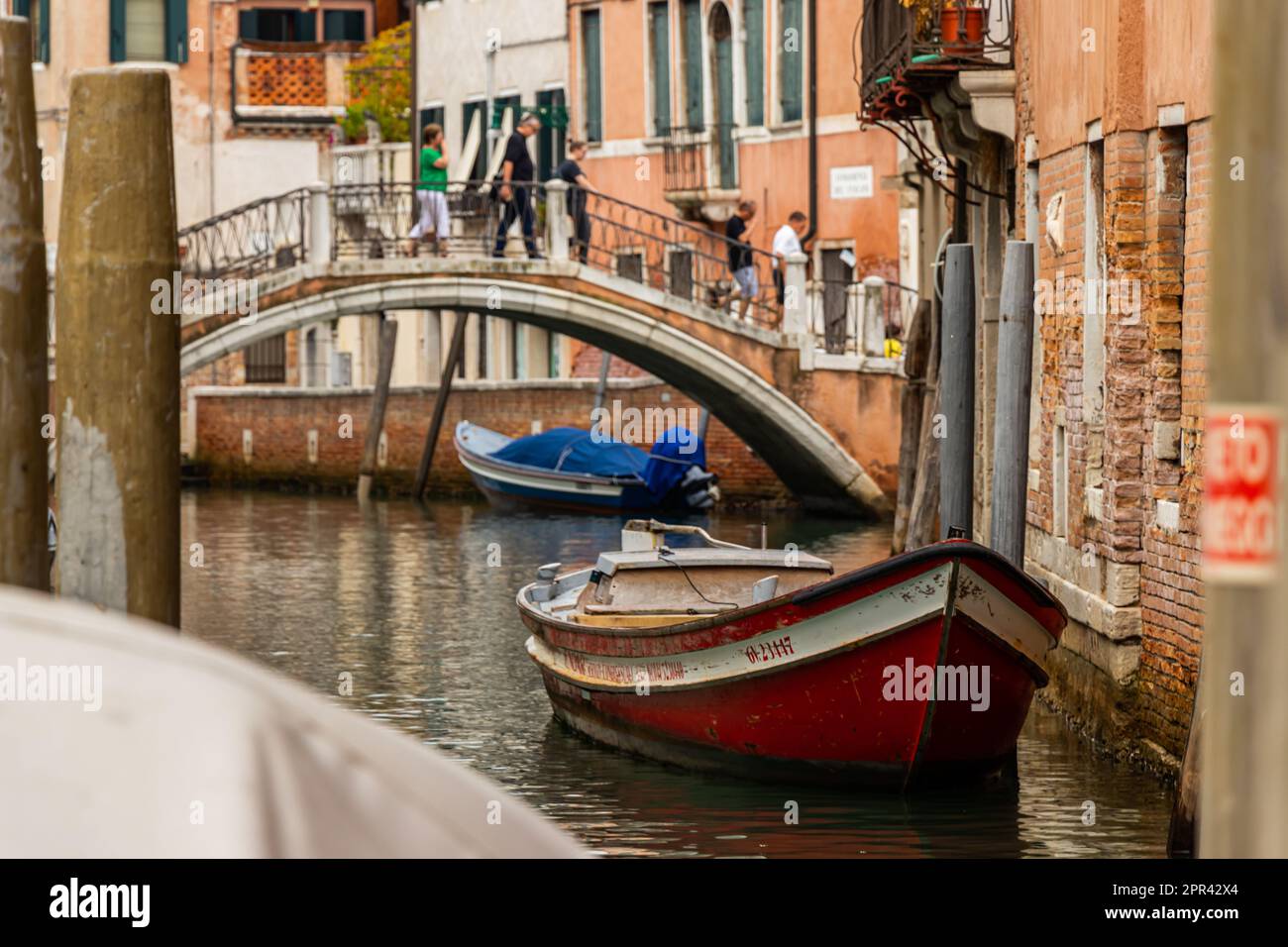 Barca ancorata sul canale con Ponte a Venezia Foto Stock