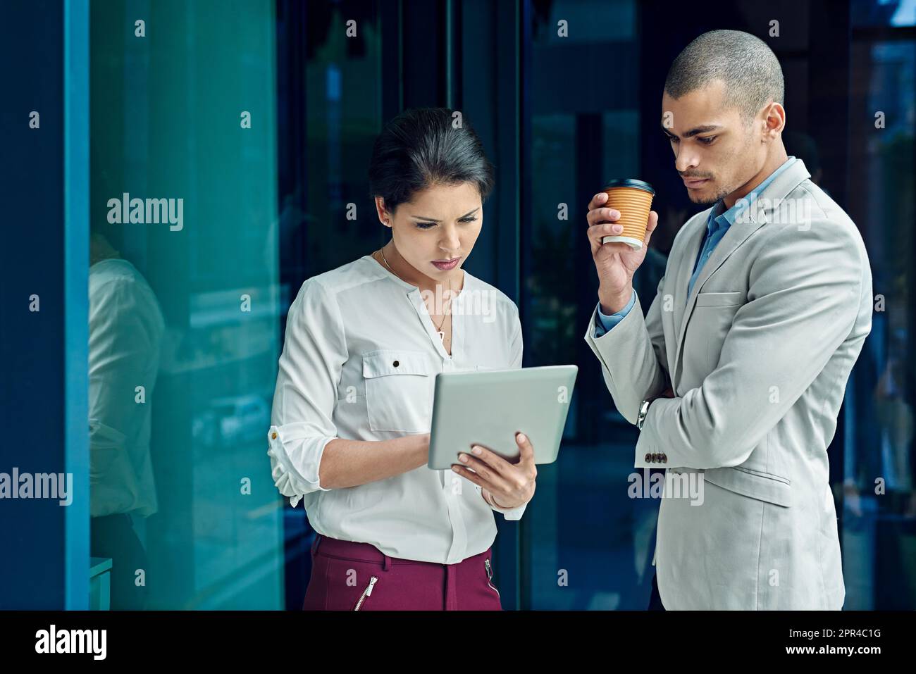 Le sessioni di feedback regolari li rendono dipendenti di livello superiore. due giovani colleghi che utilizzano un tablet digitale insieme al lavoro. Foto Stock