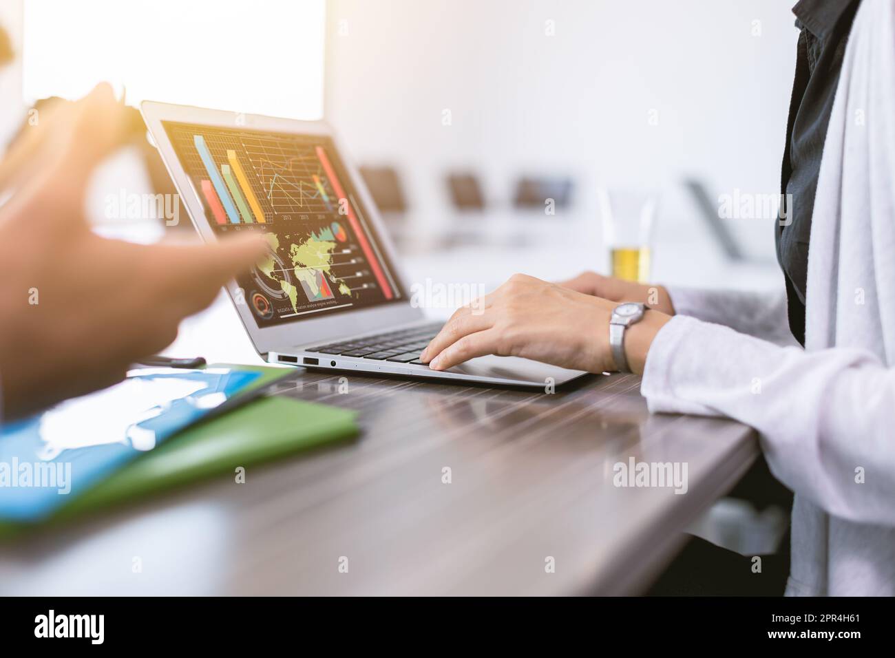 primo piano businesswoman a mano digitando in computer portatile con business grafico informazioni aziendali in schermo Foto Stock
