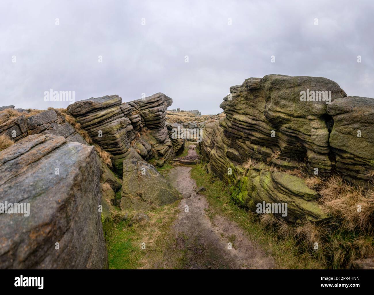 Formazioni rocciose di gritstone vicino Sandy Heys, sul bordo di Heyfield di Kinder Scout nel Derbyshire Peak District, in una giornata nuvolosa e colma Foto Stock