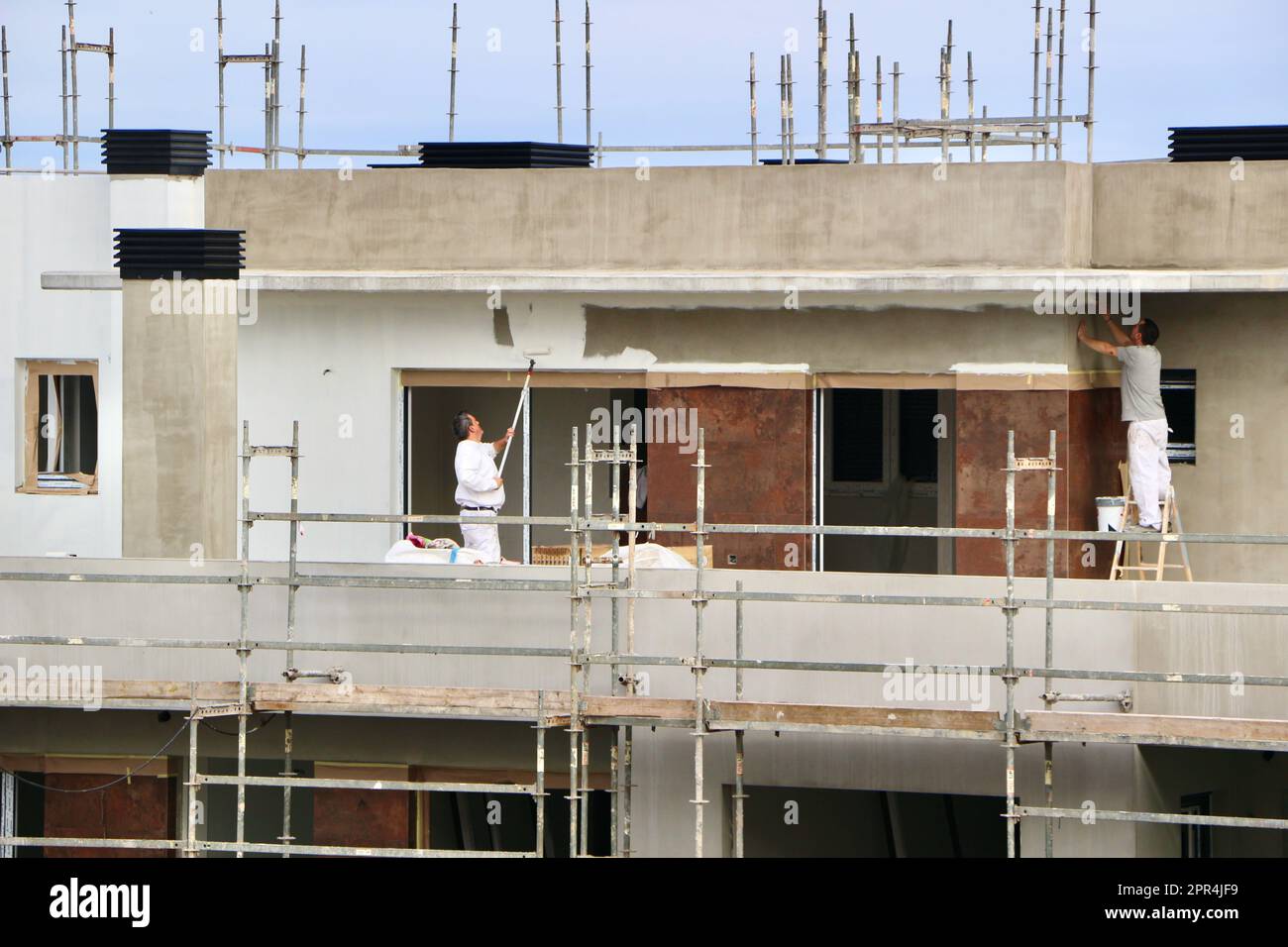 Pittori che lavorano su un blocco di cemento di recente costruzione di appartamenti Santander Cantabria Spagna Foto Stock