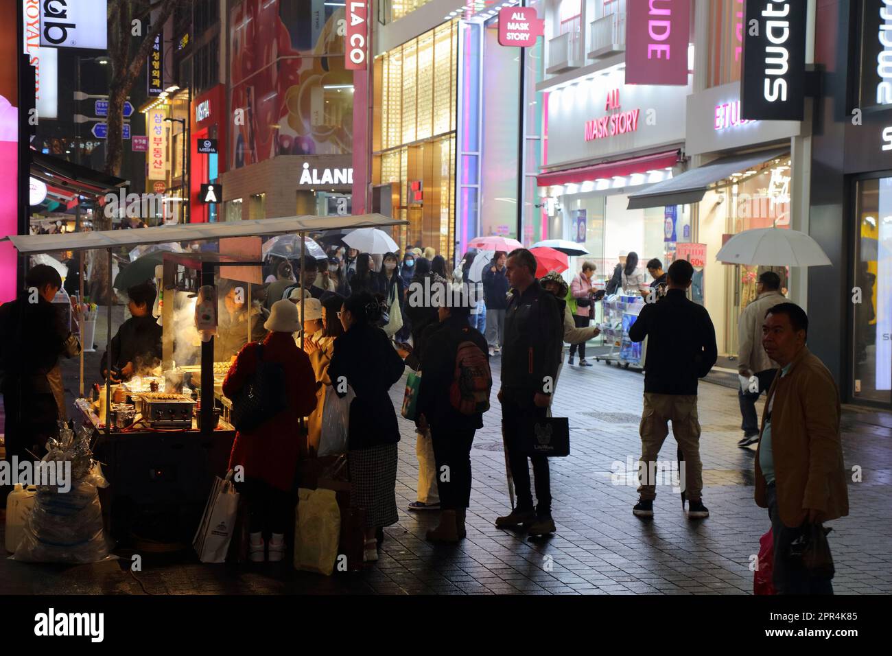 SEOUL, COREA DEL SUD - 5 APRILE 2023: La gente visita il quartiere dello shopping di Myeongdong mercato notturno bancarelle di cibo di strada a Seoul. Foto Stock