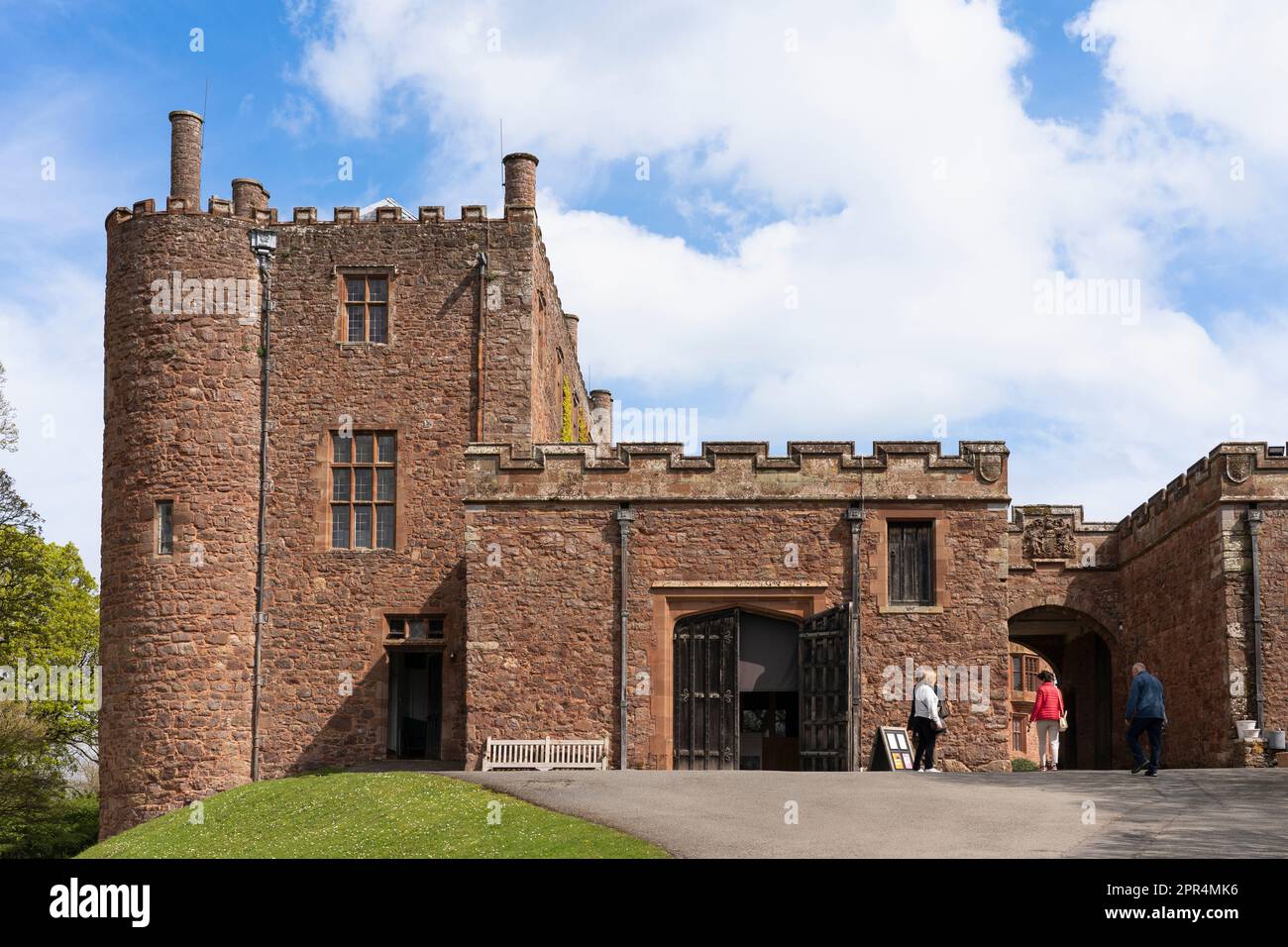Persone che entrano nel cancello esterno ingresso al Castello di Powis, una fortezza medievale di arenaria di grado 1 e casa di campagna vicino a Welshpool, Galles Foto Stock